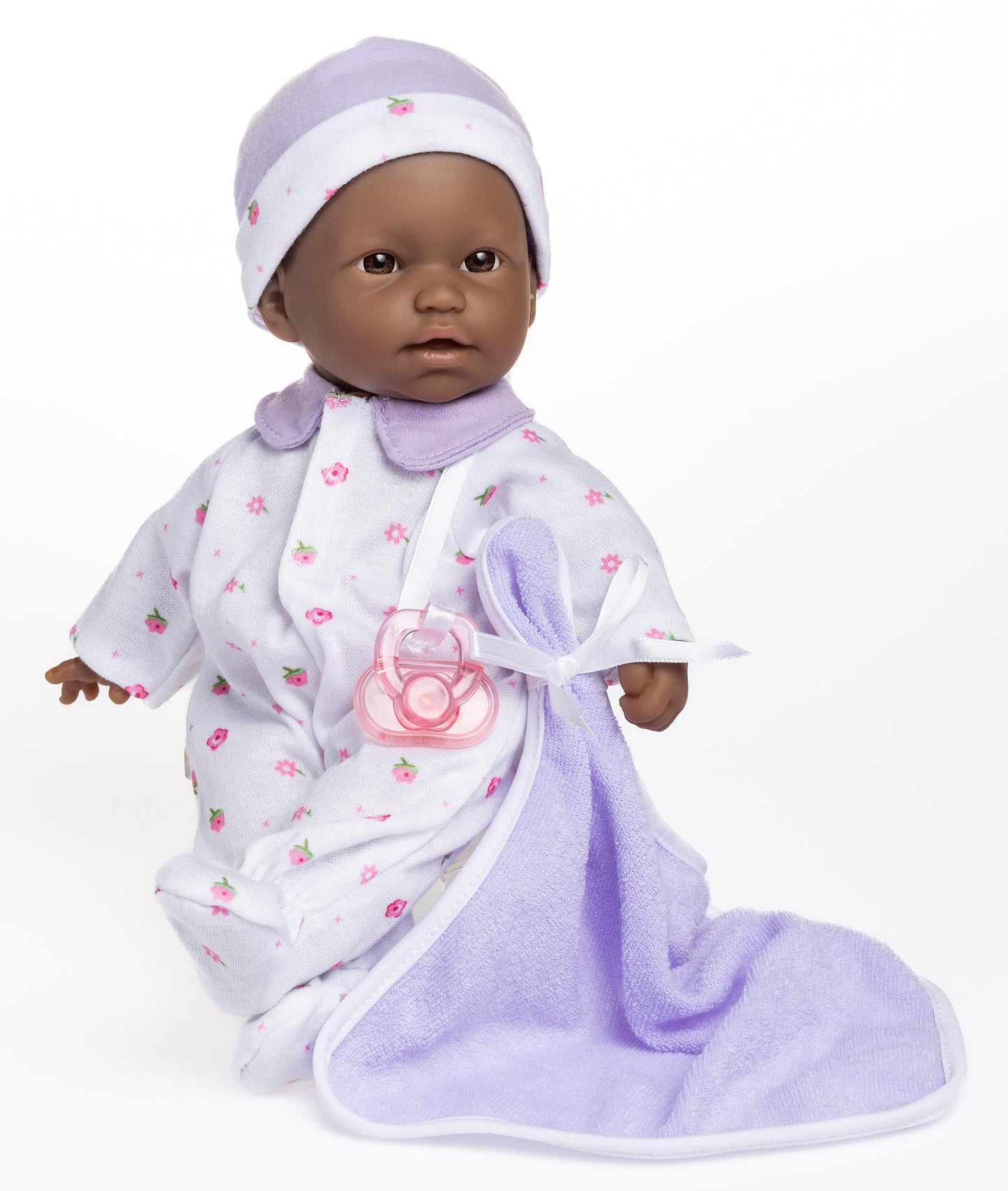 11" Soft Body Doll Dressed in Purple and Flower Print outfit. Doll is wearing a hat, and can use pictured pacifier and blanket