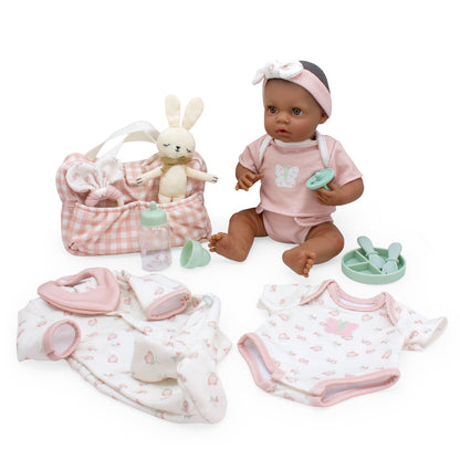 Baby doll with pink outfit and accessories on a white background