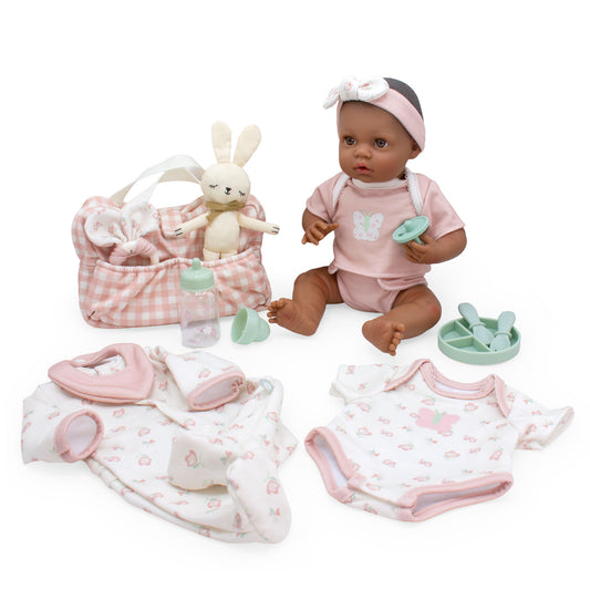 Baby doll with pink outfit and accessories on a white background