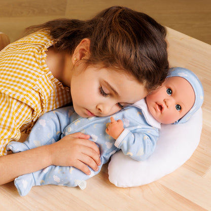 Child holding a baby doll on a wooden surface