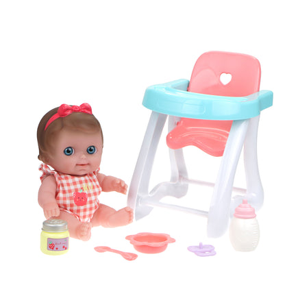 A Lil' Cutesies doll in a checkered outfit sitting next to a pink high chair with accessories including a bottle, bowl, spoon, and a diaper.