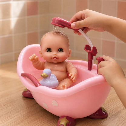 Child's hand showering a Lil' Cutesies baby doll in a pink bathtub with a working pump shower and rubber duck.