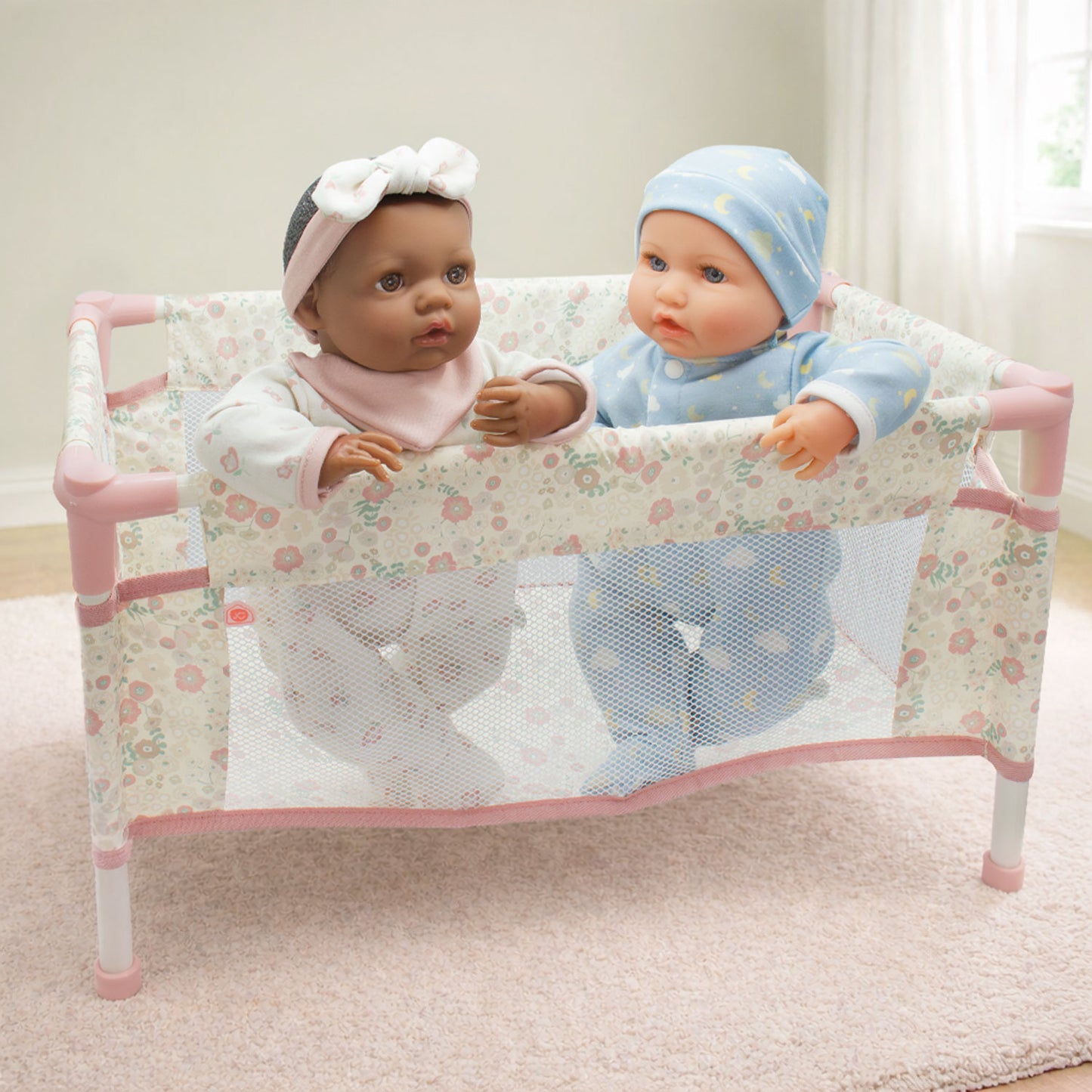 Two dolls in a floral crib with a soft focus background