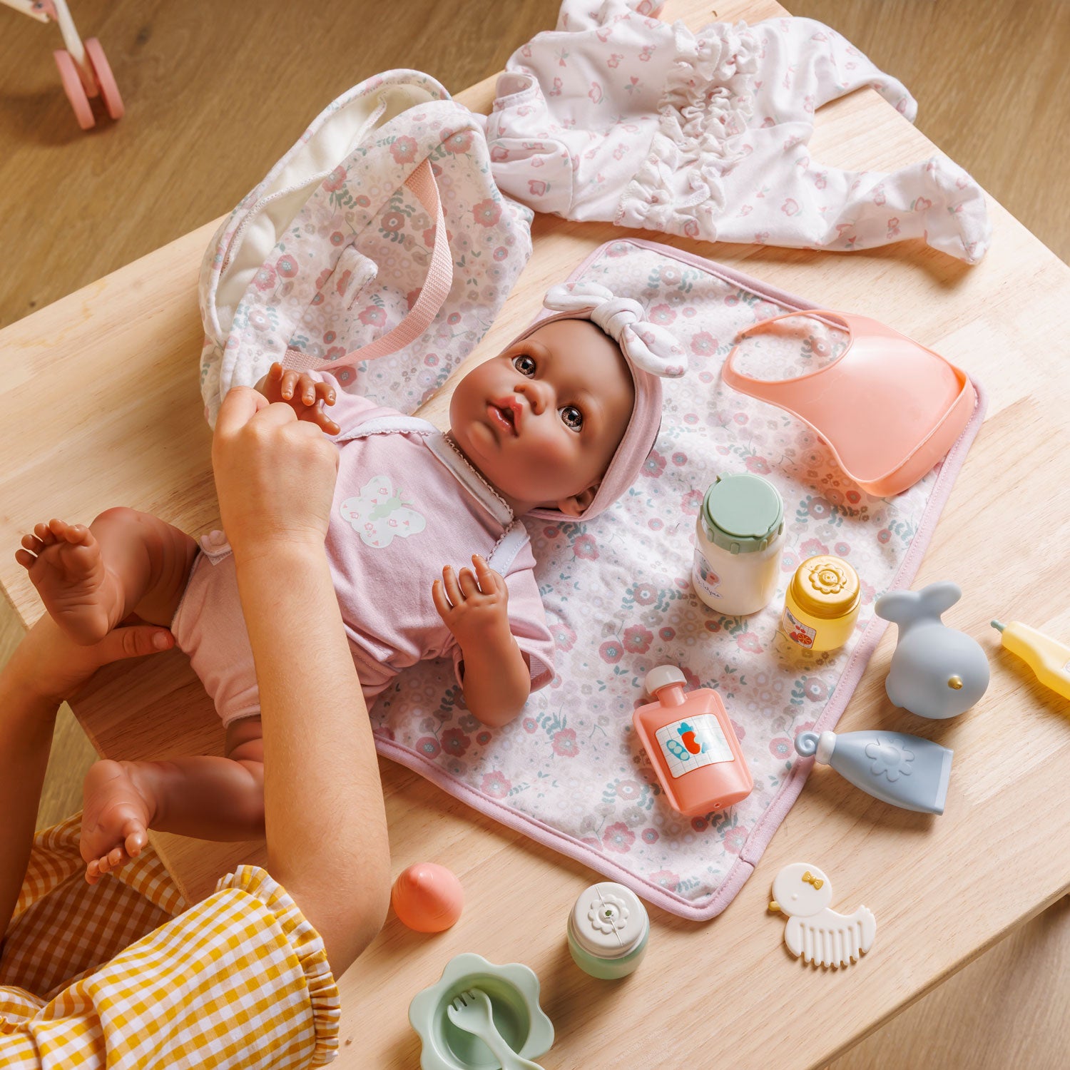 Baby doll with accessories on a wooden surface
