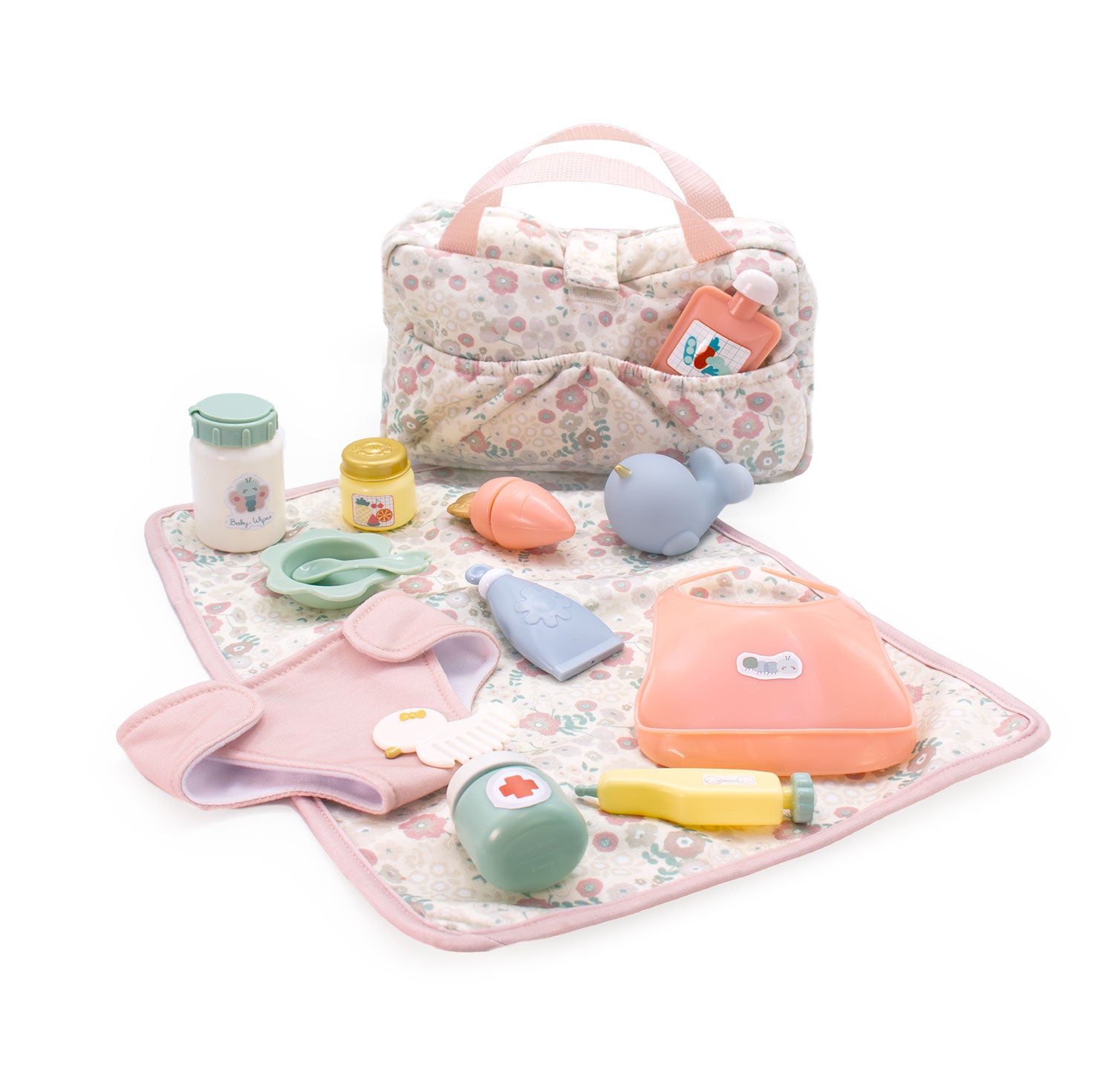 Set of baby toys and accessories on a floral blanket with a floral-patterned bag.