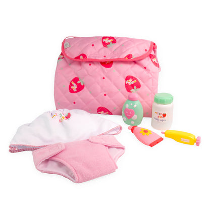A pink and white diaper bag with a quilted design, featuring a variety of baby accessories including a diaper and a t-shirt. The bag unfolds into a changing station.
