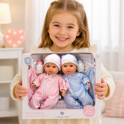 Smiling girl holds a boxed set of 12.5" soft-body twin baby dolls: one boy in blue, one girl in pink.