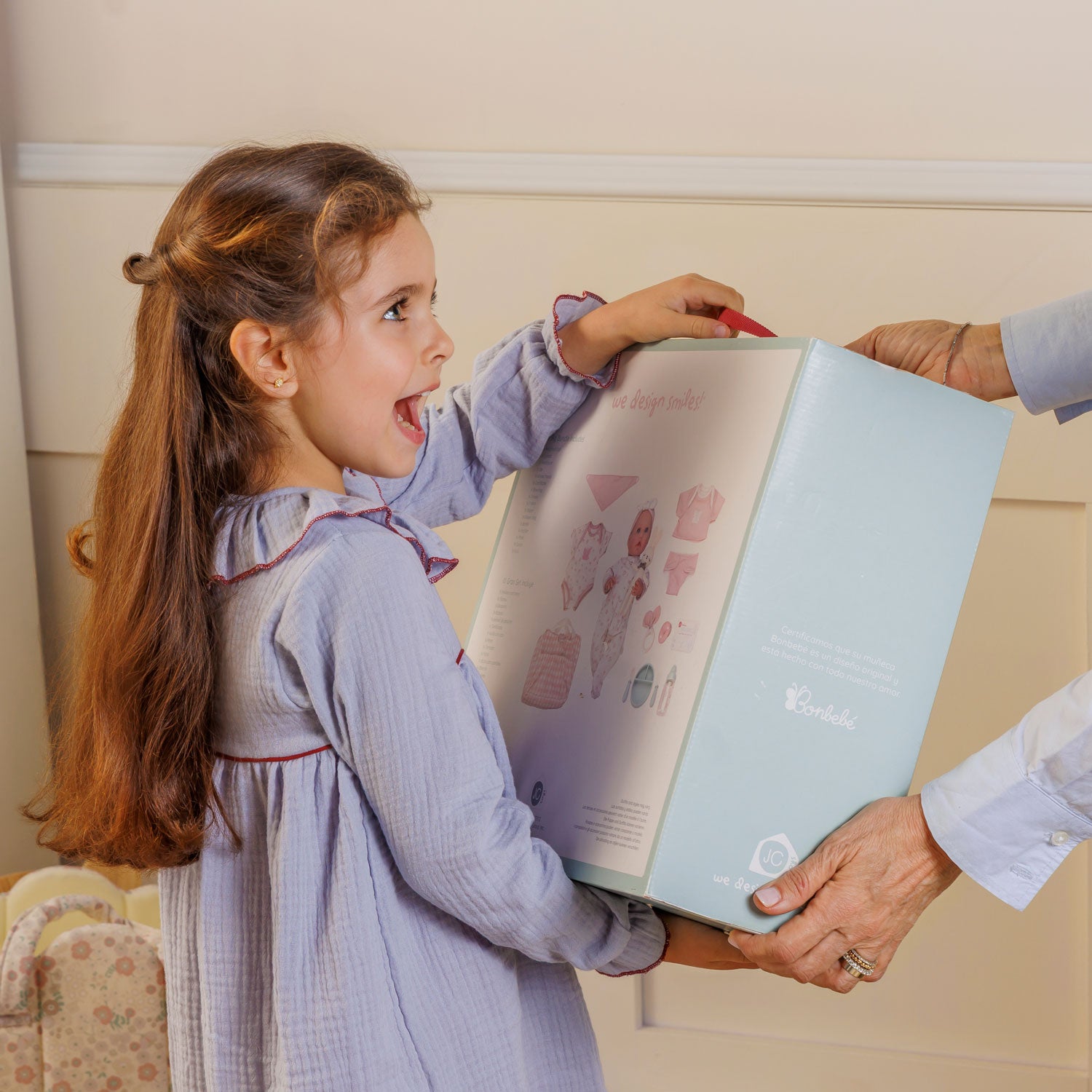 Child opening a light blue folder with a person's hand assisting, in a home setting.