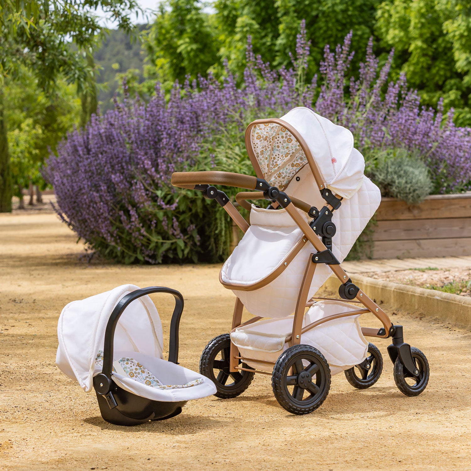 White stroller with canopy in a garden setting with lavender bushes