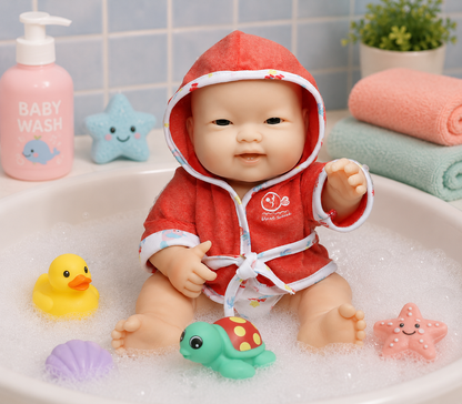 Baby doll in a red bathrobe with bath toys in a bathtub