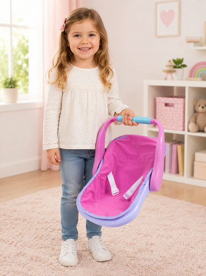 Child holding a pink and purple baby carrier in a room with a bookshelf and teddy bear.